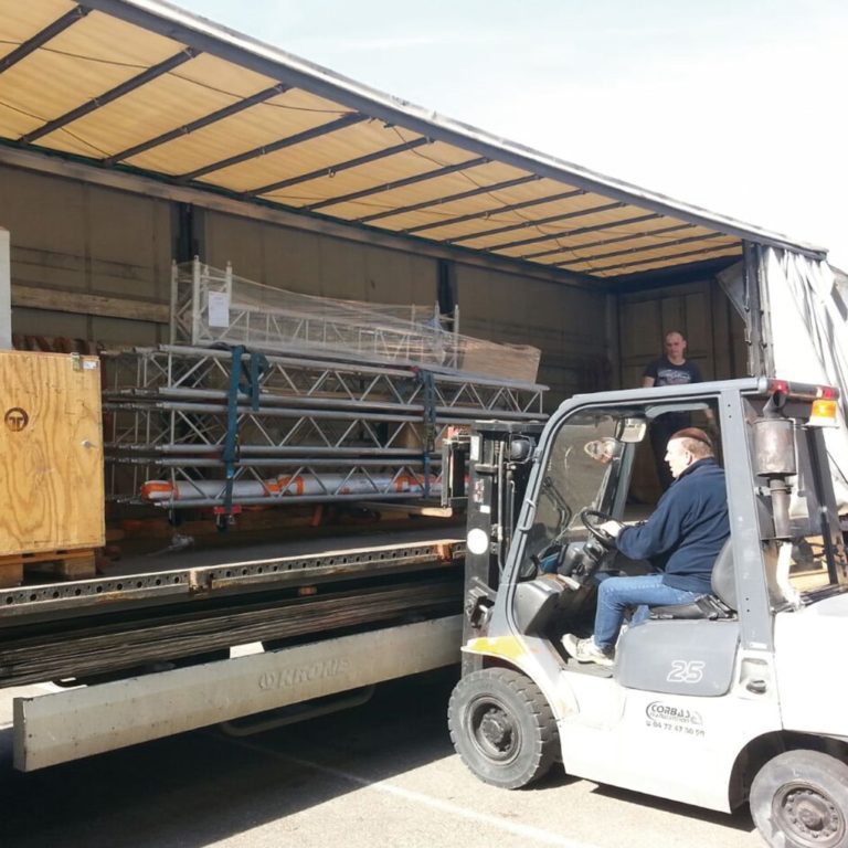 Cross beams are lifted out of a truck with a forklift truck Furniture logistics