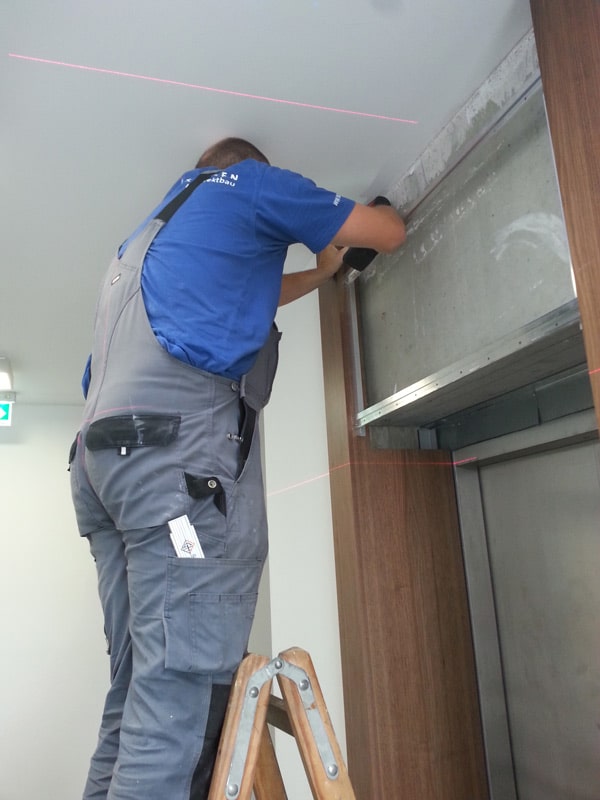 An assembler applies veneers and wall coverings