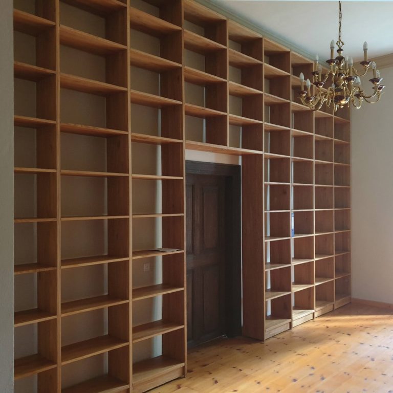 a high-quality archive wall shelves system empty and an old chandelier