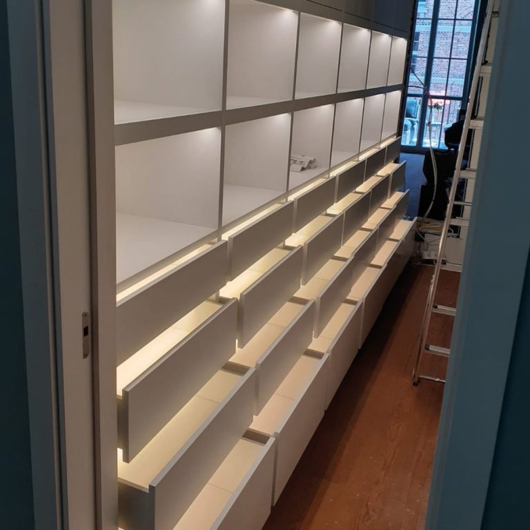 a lighted built-in cabinet with shelves and drawers
