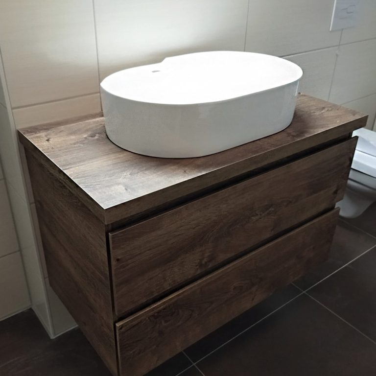 oval white washbasin mounted on high quality wooden schrabk in the bathroom