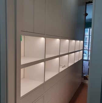 an illuminated white wall built-in cabinet