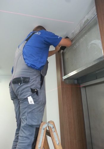 An assembler applies veneers and wall coverings